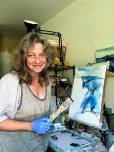 Irene Duma in her studio, holding a paint brush