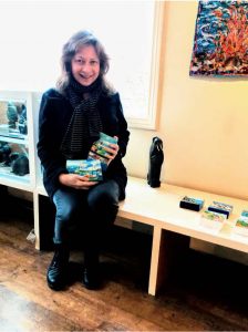 Irene Duma poses with her mini paintings in Red Ochre Fine Art Gallery