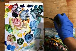 Irene paints a mini painting with a palette knife