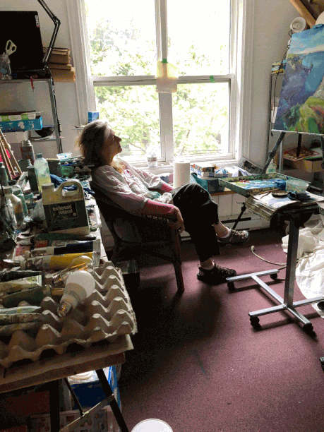 an animated gif of the artist Irene Duma in her studio, thinking and tapping her toe.