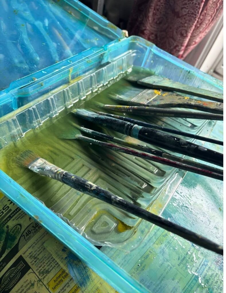 Oil paint brushes with the bristles submerged in safflower oil.